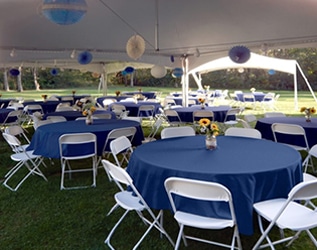 Garden party setup with tables chairs and tent