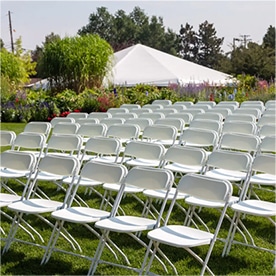white folding chairs at a garden wedding