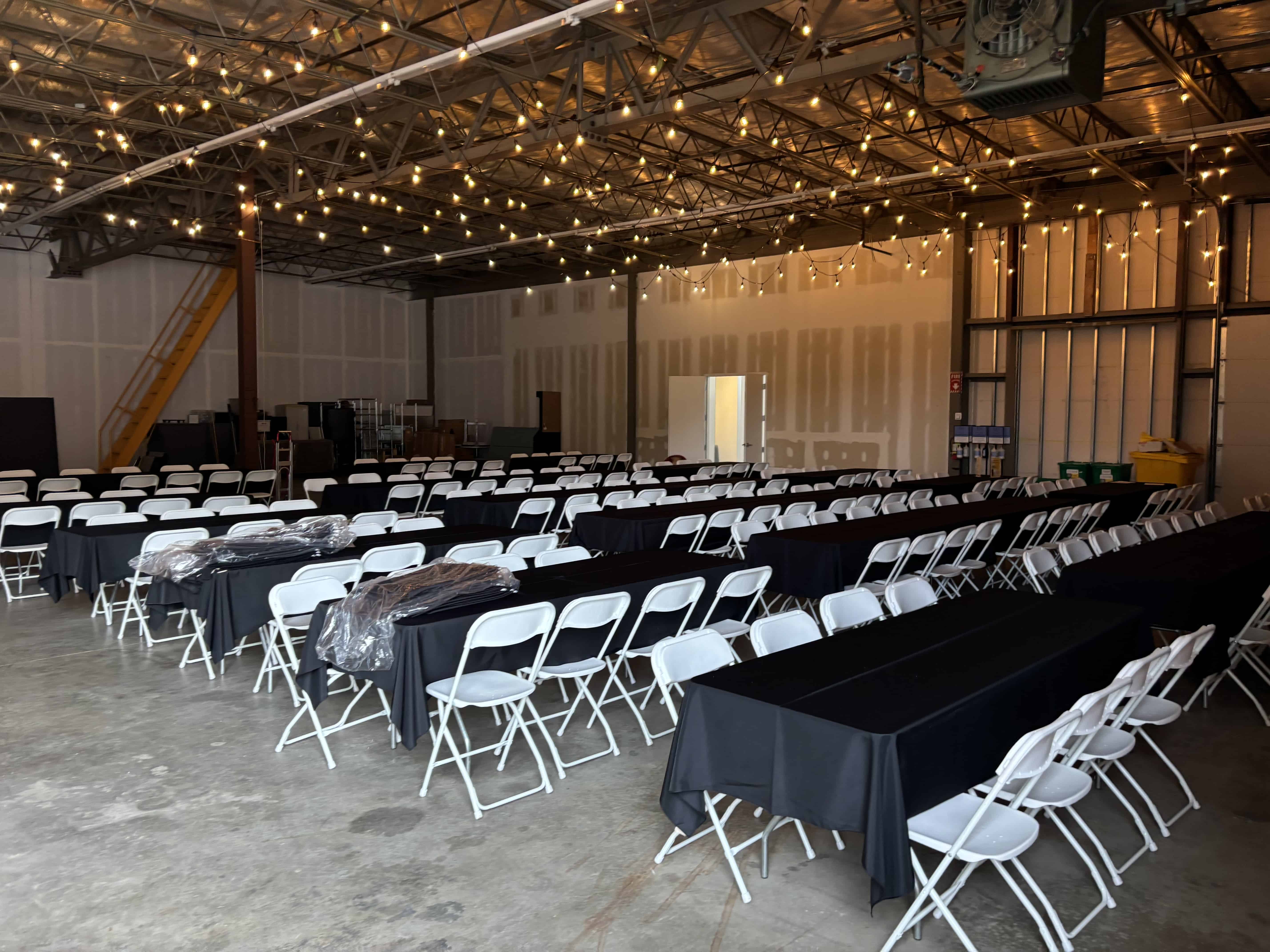 White chairs with black table clothed tables