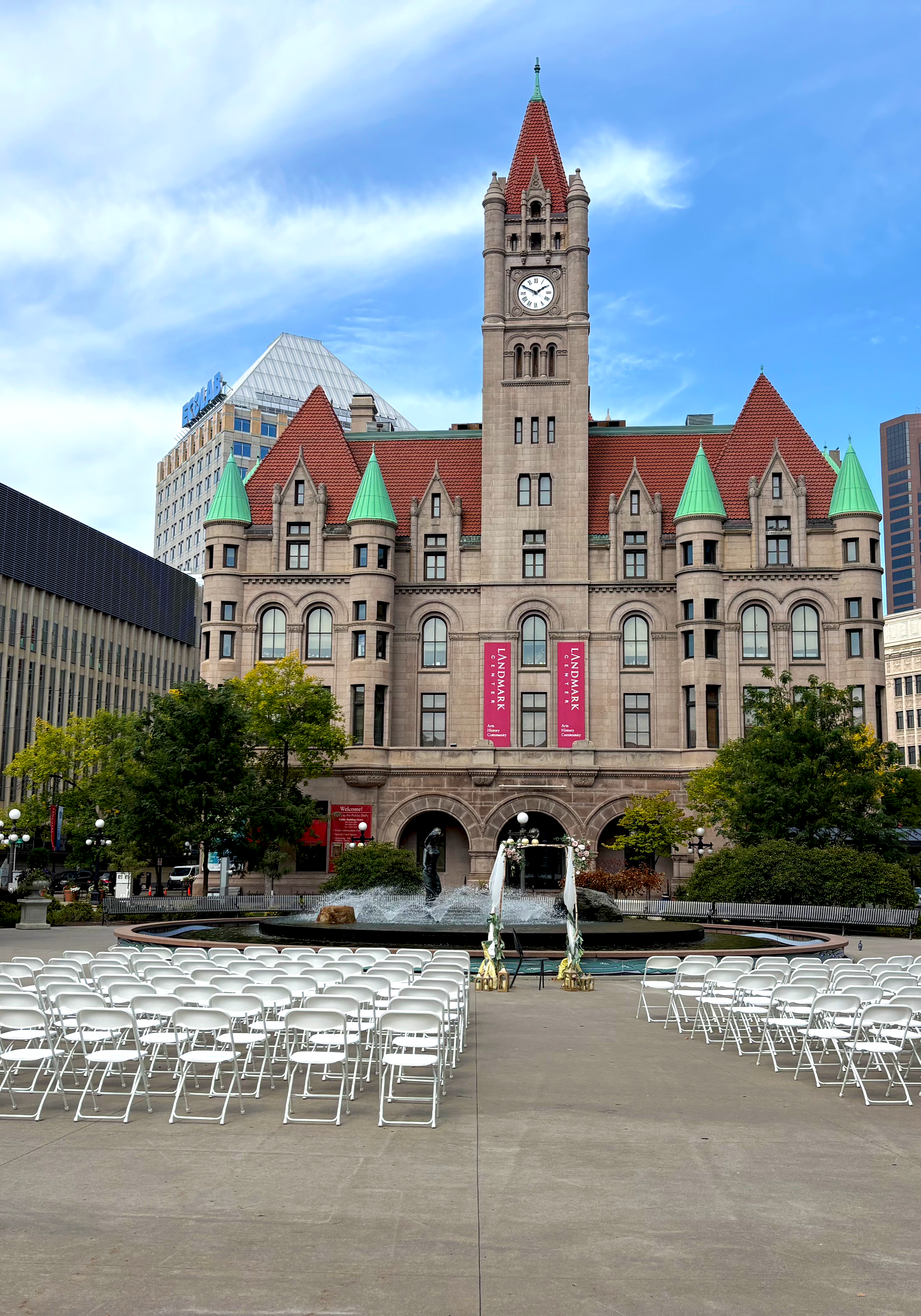 city square wedding with white chairs at a fountain